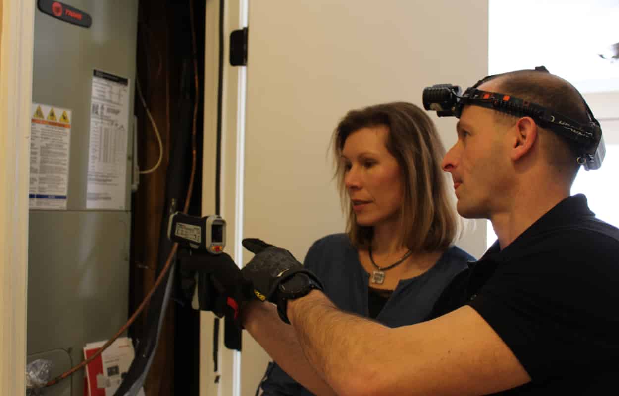 Inspector Todd Thuss inspecting an HVAC unit with a client