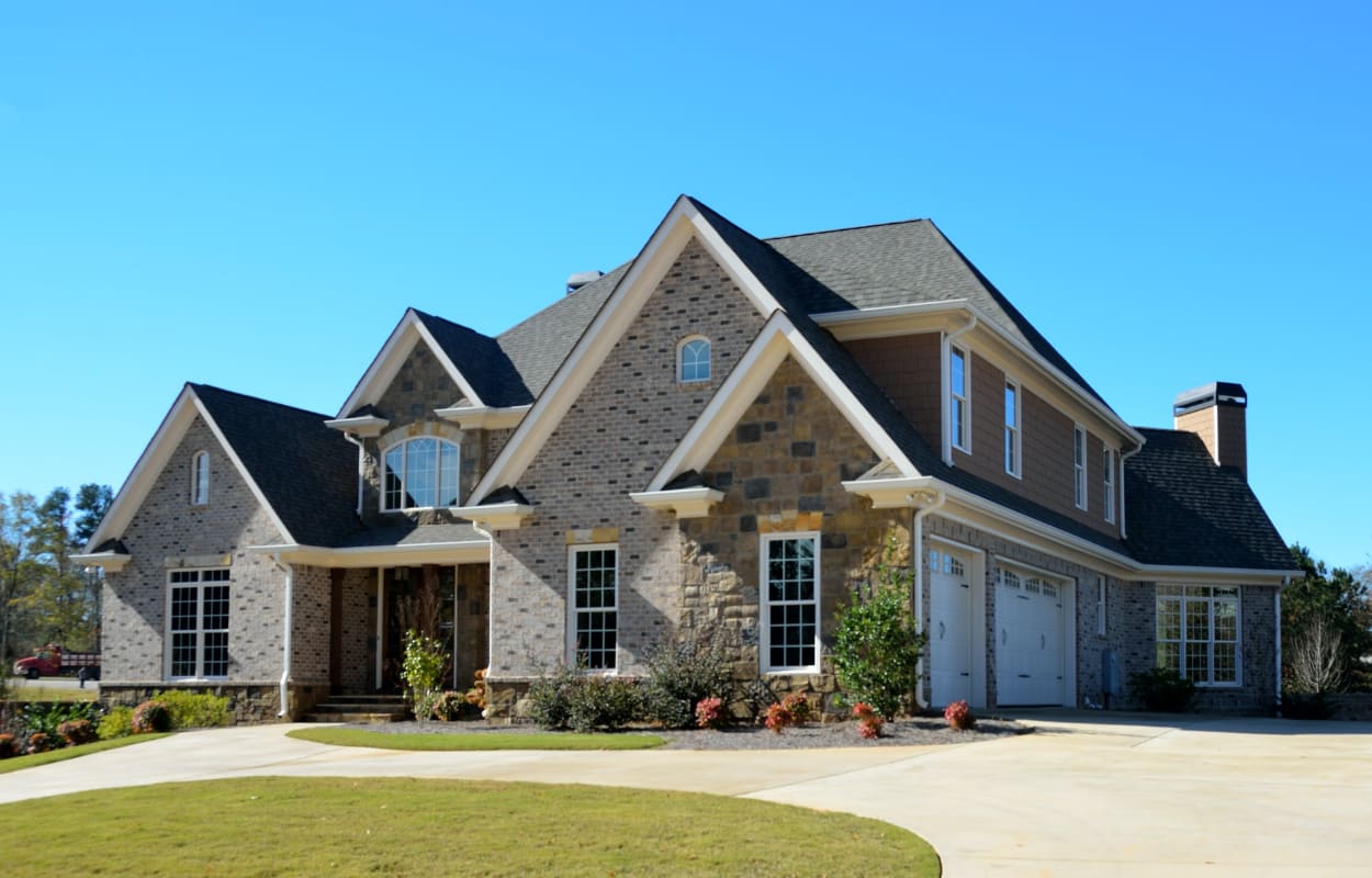 Photo of an attractive brick and stone home in a typical subdivision, a typical home inspected during a home buyer's home inspection.