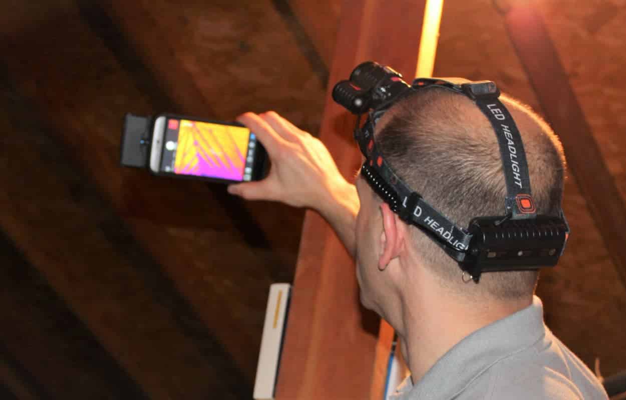 Home Inspector Todd Thuss inspecting an attic with an infrared camera